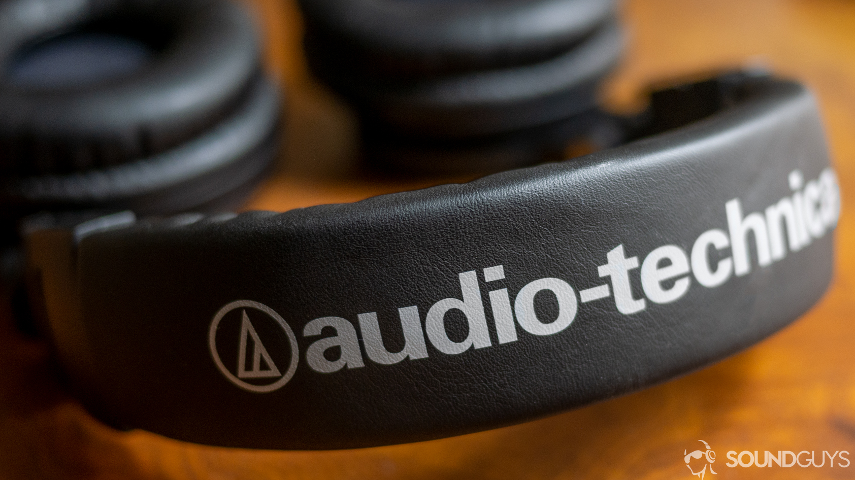 audio-technica-ath-m50xbt-band A photo of the Audio-Technica ATH-M50xBT on a wooden desk.