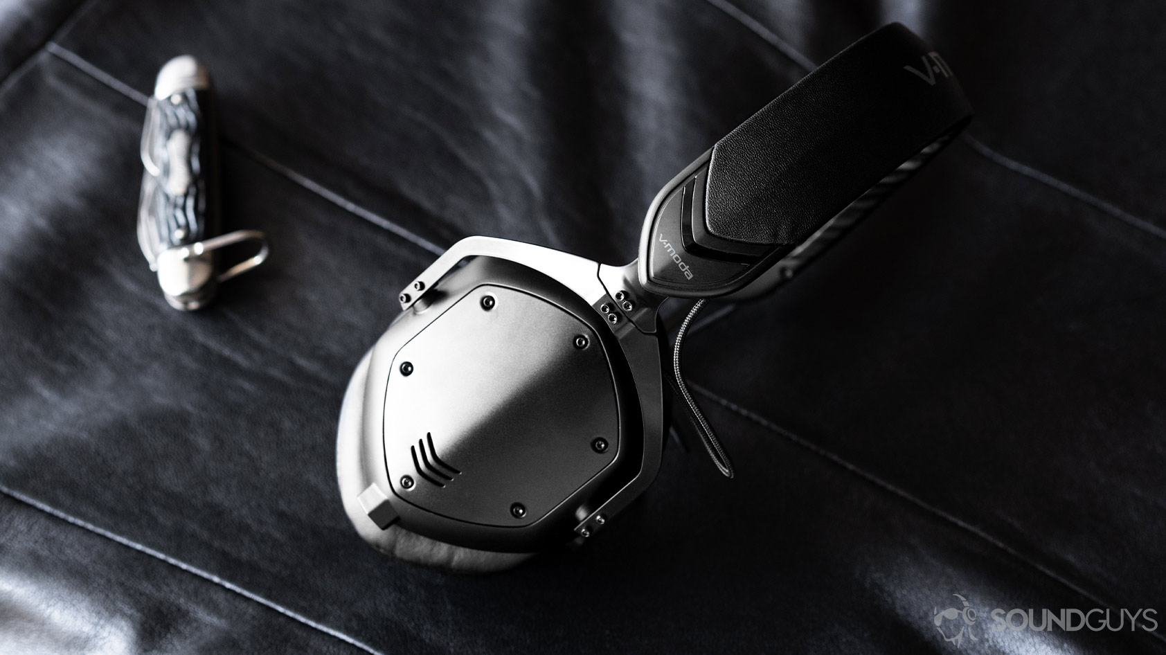 VModa_M100 Master-1_headphones plate metal The V-Moda M-100 Master headphones on a leather surface.
