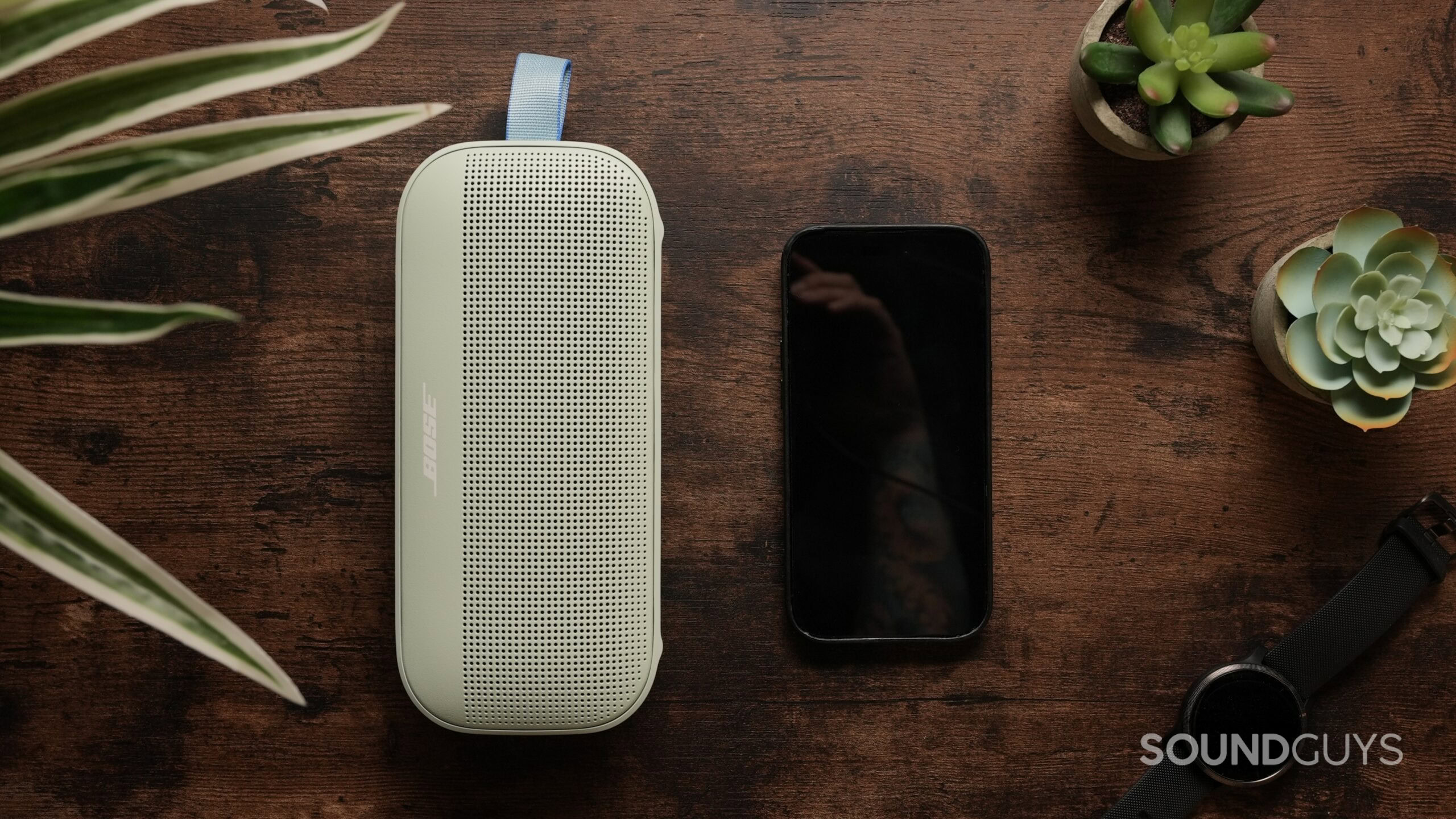 Bose SoundLink 2nd Gen_6 Top down photo of a Bose SoundLink Flex Gen 2 speaker, next to an iPhone 14 Pro.